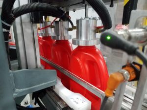 Large HDPE Bottles on conveyor going through leak testing station
